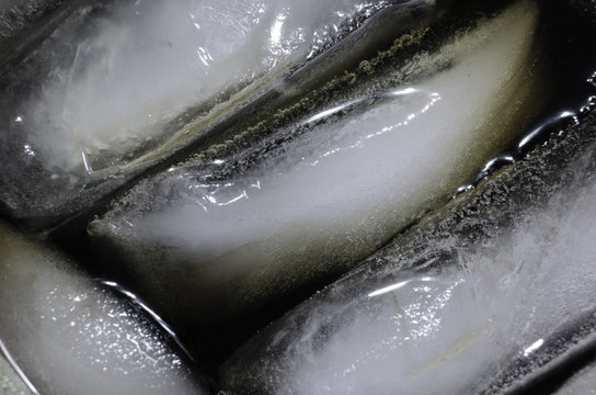 ice cubes floating in glass of soda closeup macro macrophotograph bubbles