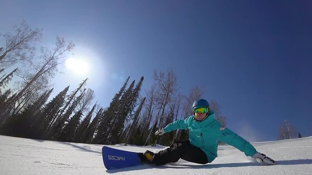 professional snowboarder touching snow with hand, made nice turns in on the mountainside. slow motion