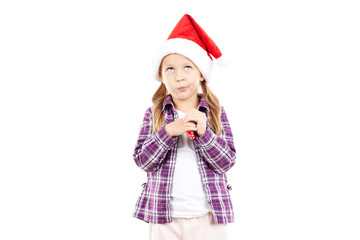 Portrait of sweet little girl in Santa hat blowing into party blower