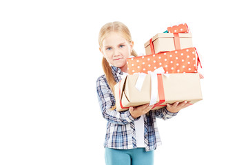 Studio portrait of little girl holding stack of Christmas gifts