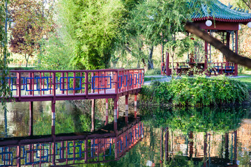 Red Bridge and Gazebo by a Pond
