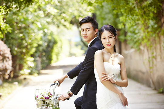 asian wedding couple riding bicycle
