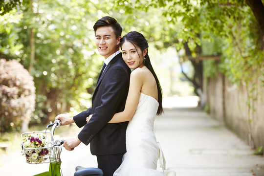 asian wedding couple riding bicycle