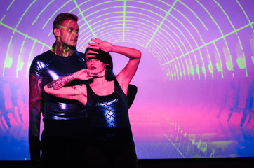Fototapeta premium the girl with the guy in the background of the projector screen . Love couple DJs and play music . Festive disco