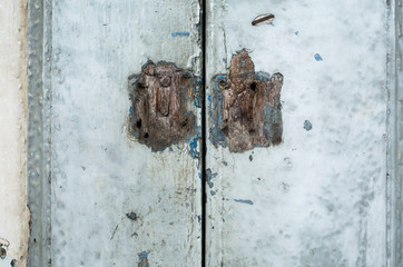 Old rusty lock is damaged with old wooden door, closeup