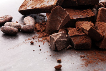 Raw cocoa beans, cocoa powder and chocolate pieces.