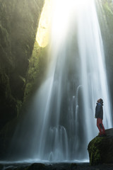 Hombre de pie en una roca mirando a la impresionante cascada de Gljufrabui en Islandia 