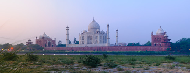 Panorama of the Taj Mahal mausoleum in Agra, India, seen from the other bank of the river, near the Garden of the Moon, at dawn.