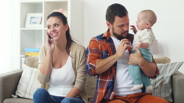 father with baby and mother calling on smartphone
