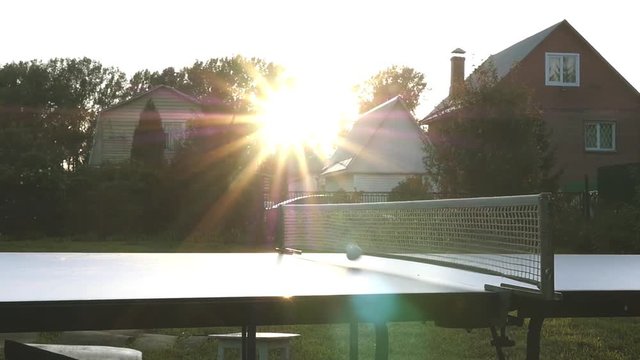 To throw a ball of table tennis on the pitch in the rays of the sunset. slowmotion, 1920x1080, hd