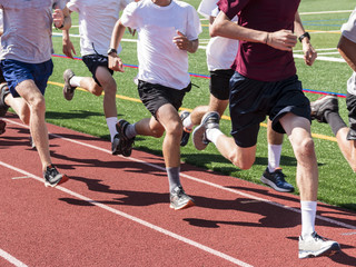 Boys running fast on a track in a group training run