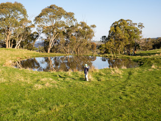 Young boy investigating a dam on a farm