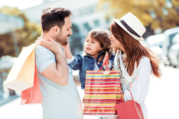 Family with shopping bags after shoping in city street.