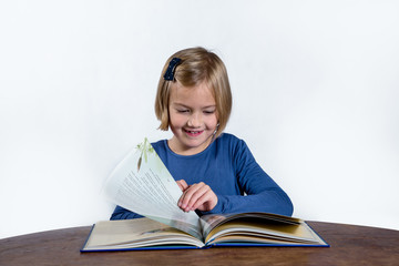 smiling little girl with a book on a white background