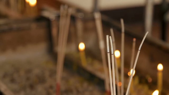 Religious yellow candles and aromasticks. Wat Saket, Bangkok, Thailand.