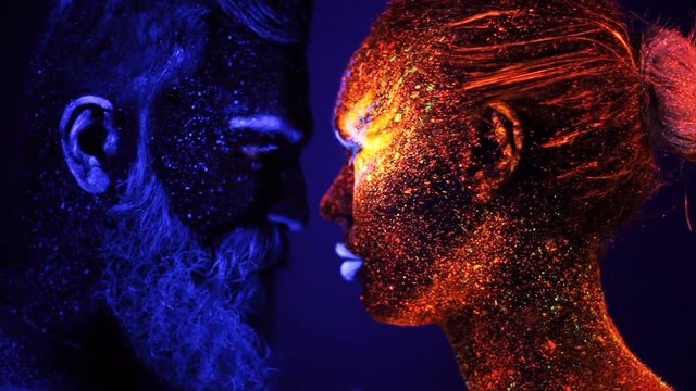Portrait of a bearded man and woman painted in ultraviolet powder