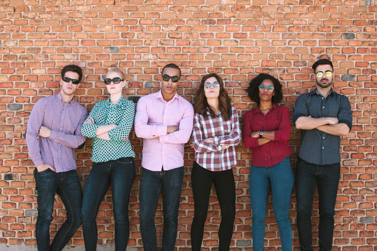Young Entrepreneurs Posing Besides a Brick Wall