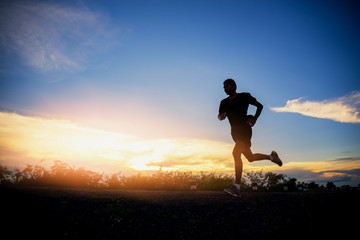 Young man running on a rural road during between the summer on vacation, run for health according nature on a rural, Early in the morning or before sunset.