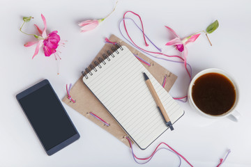 Creative flat lay photo of workspace desk with smartphone, coffee, pencil, flowers with copy space background. Flat lay.