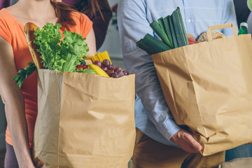 man and woman holding paper bags with food