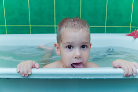 Boy in white bath tub on white background