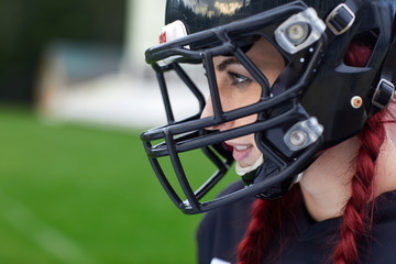 Woman American football player in helmet