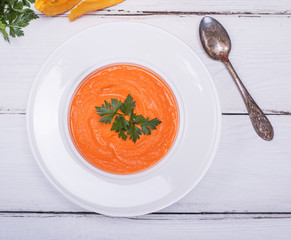 white round plate with cream of pumpkin soup