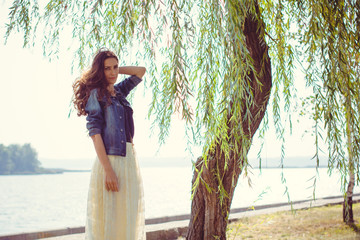 A middle-aged woman rests on a city waterfront on a day off. The concept of femininity and romance...