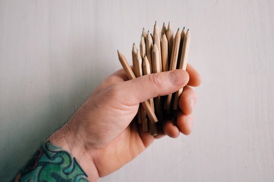 A group of small brown pencils arranged on a white table