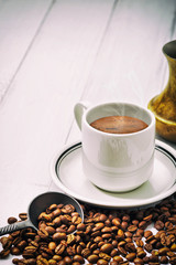 Coffee cup and beans on old kitchen table. Top view with copyspace for your text