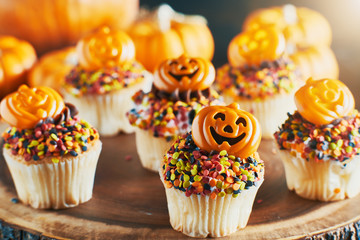 festive halloween pumpkin cupcakes with chocolate frosting and colorful sprinkles