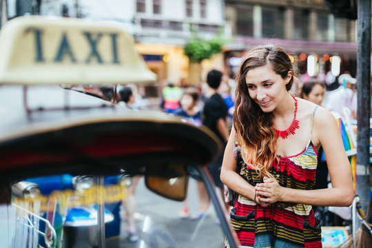 Woman using a tuc tuc to move around Bangkok, Thailand.