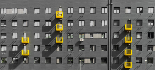 Exterior of gray residential building with yellow balcony