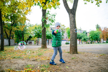 Fototapeta premium little kid boy playing with soap bubbles