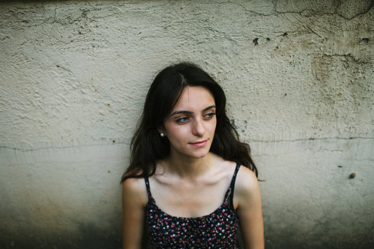 Young woman by concrete wall