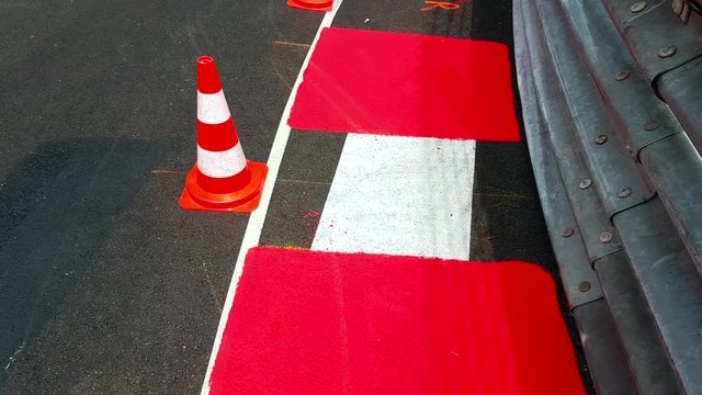 Texture of Race Asphalt and Curved Curb With Traffic Cones