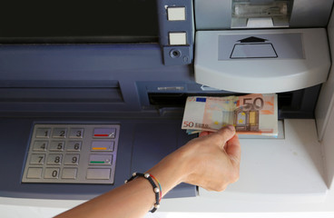 girl takes money from the ATM in Europe