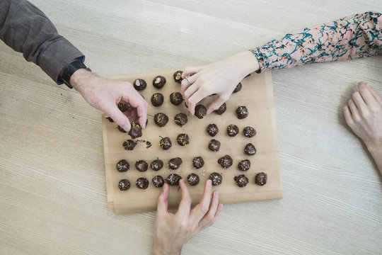 Hands taking pieces of chocolate candy