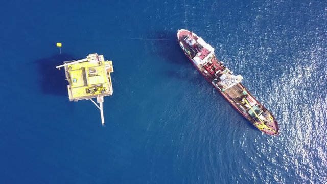 An aerial view from a drone of a soil boring boat (a geotechnical drilling cum analogue survey vessel) close to a oil platform
