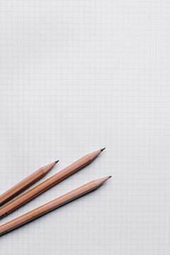 3 pencils on a white grid paper, with copyspace