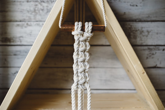 Macrame hanging from wood triangle shelf