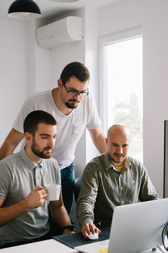 Three Male Colleagues Working At the Office