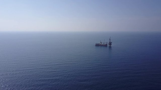 An aerial view from a drone of  a tender drilling oil rig (Barge Oil Rig) on the production platform on sunny day
