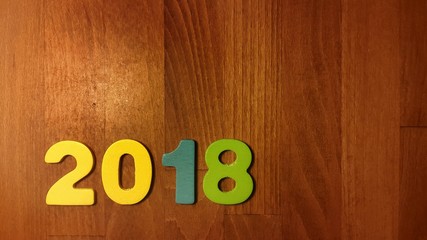 Wooden olored numbers forming the number 2018, For the new year 2018 on a wooden background.