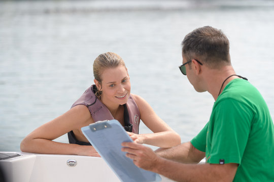 Man with clipboard talking to woman in the water
