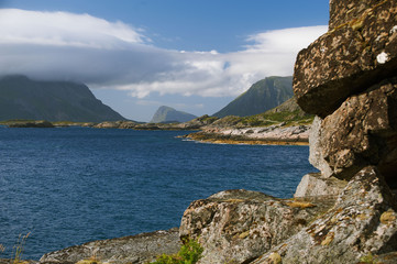 Fototapeta na wymiar Sea landscape with mountains, rocks and white clouds