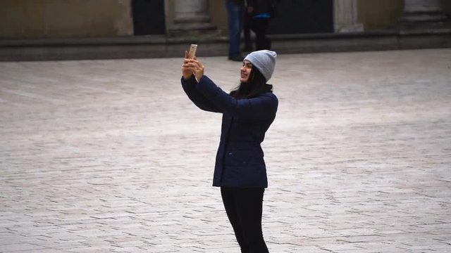 Girl makes selfie is standing on the square