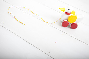 toy wooden duck on white painted floor boards