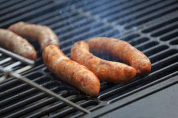 Appetizing pork sausages are cooked on the grill with a smoke