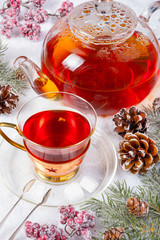 cup of tea with tea pot and decoration on snow in winter